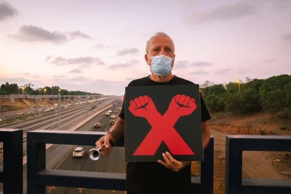 דב שמש המפגין שצילם בהפגנה קודמת על גשר קק"ל